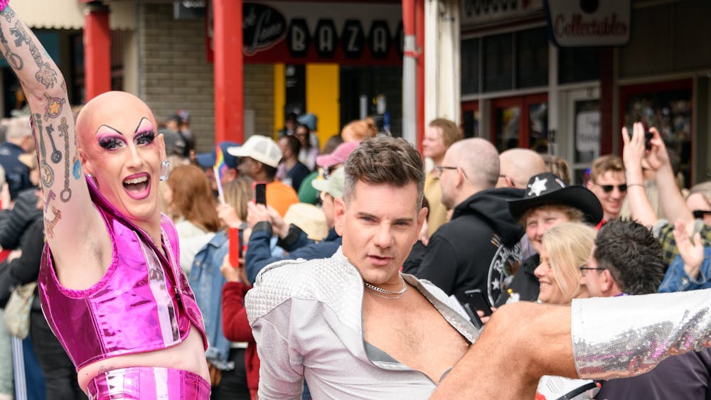 Two people pose extravagantly on parade car