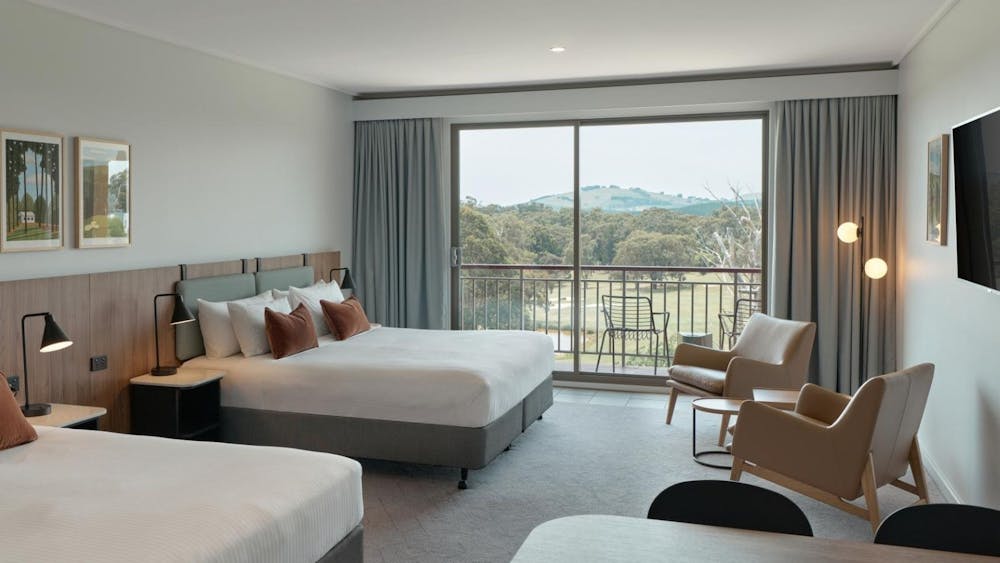 Fairway Room featuring beds, arm chairs, TV and dining table.